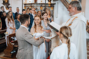 The priest places a ceremonial cloth over the couple's hands and blesses their union