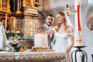 Bride and groom light the wedding candle together at the altar