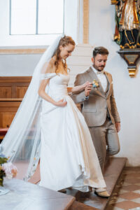 The newlyweds walk hand in hand down the church steps