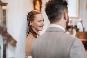 Photographed over the groom's shoulder as his wife looks at him lovingly