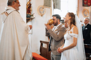 The groom drinks from the sacred chalice during the mass