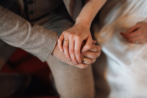 Close-up of the couple's hands holding each other lovingly