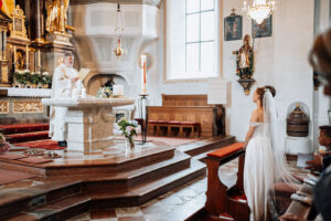 Wide-angle photo of the priest preaching behind the altar
