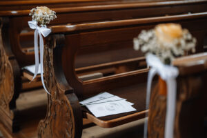 Detail photo of a church pew with a wedding program booklet
