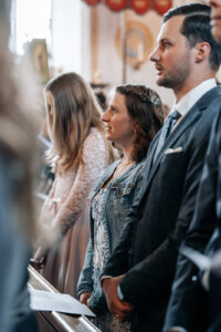 Portrait among the church pews focusing on the bride's friend singing