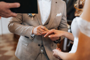 Close-up of the wedding ring being placed on the bride's finger.