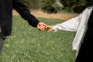 Close-up of a couple holding hands in a flower meadow