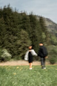Vintage blurry photo of a young couple holding hands in a flower meadow