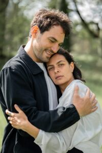 Photo of a couple embracing while the woman gazes dreamily into the camera
