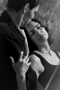 Dreamy vintage black-and-white photo of a young couple with the man kissing the woman on the forehead