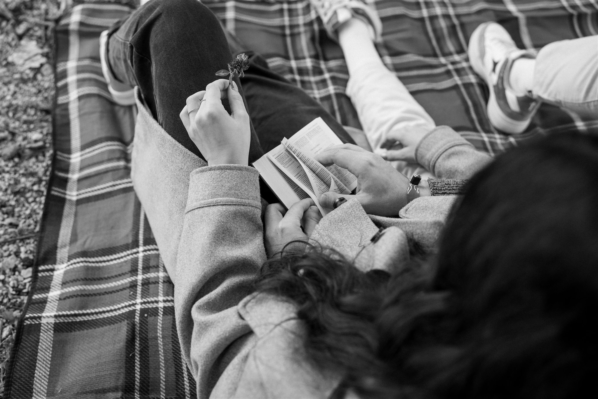 Black-and-white over-the-shoulder photo of a young man turning pages in a book