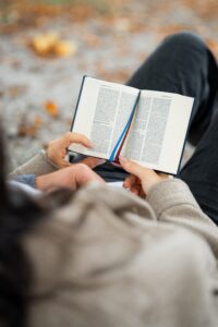 Over-the-shoulder detail shot of a book with visible Bible verses