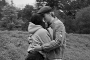 Black-and-white photo of a couple embracing tightly with visible motion blur