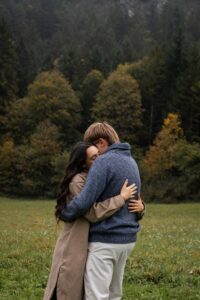 Vintage cinematic photo of an intimate embrace in front of autumn trees
