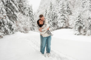 Man embracing his girlfriend from behind while both laugh and sway together