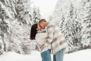 Young couple in a snowy field sharing an intimate embrace just before a kiss
