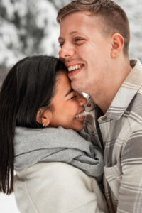 Young couple embracing with their heads together while laughing warmly