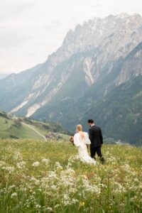 Wedding couple walking through a flower meadow while looking downward