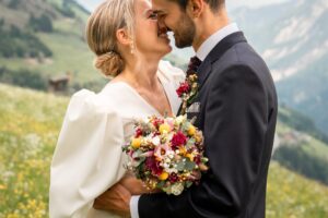 Close-up of a wedding couple leaning in for a kiss while smiling warmly