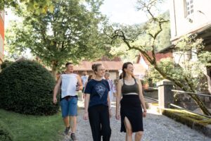 A group of young people walking across the courtyard toward the ceremony location in the morning