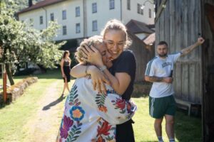 Warm embrace between the bride and one of her bridesmaids in casual clothing
