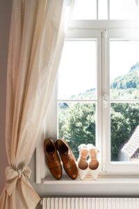 The bride’s and groom’s shoes displayed on a windowsill