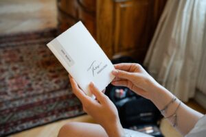 Close-up of hands holding an envelope containing wedding vows
