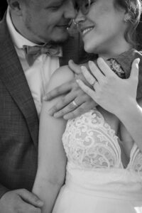 Black-and-white close-up of the wedding couple leaning their heads together, almost kissing