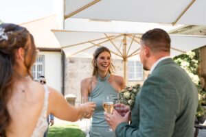 The maid of honor toasts with the wedding couple and congratulates them with a smile