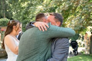 Warm embrace between the groom and a guest