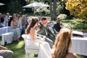 Side-view photo of the groom wiping away a tear during the ceremony