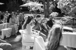 Black-and-white photo of the groom wiping away a tear during the ceremony
