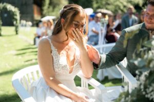 Portrait of the bride smiling with her hands covering her face during the ceremony
