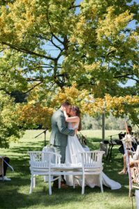 Wedding kiss beneath a large tree
