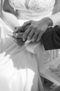 Black-and-white close-up of the wedding couple’s hands from the front