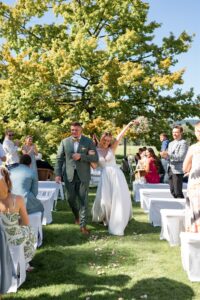 Joyful wedding recessional between cheering guests