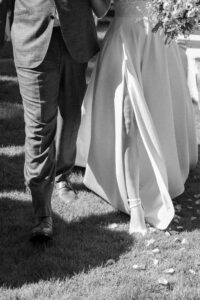 Black-and-white close-up of the couple’s lower bodies during the recessional