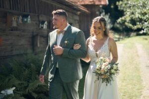 Bride and groom walk away from the venue arm in arm