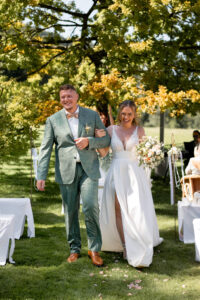Joyful wedding recessional between cheering guests