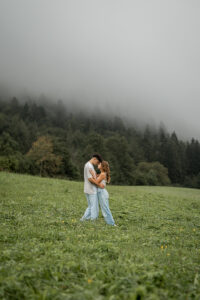 Young couple standing opposite each other in a meadow with their foreheads touching