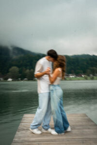Vintage cinematic motion blur photo of a couple kissing on a dock