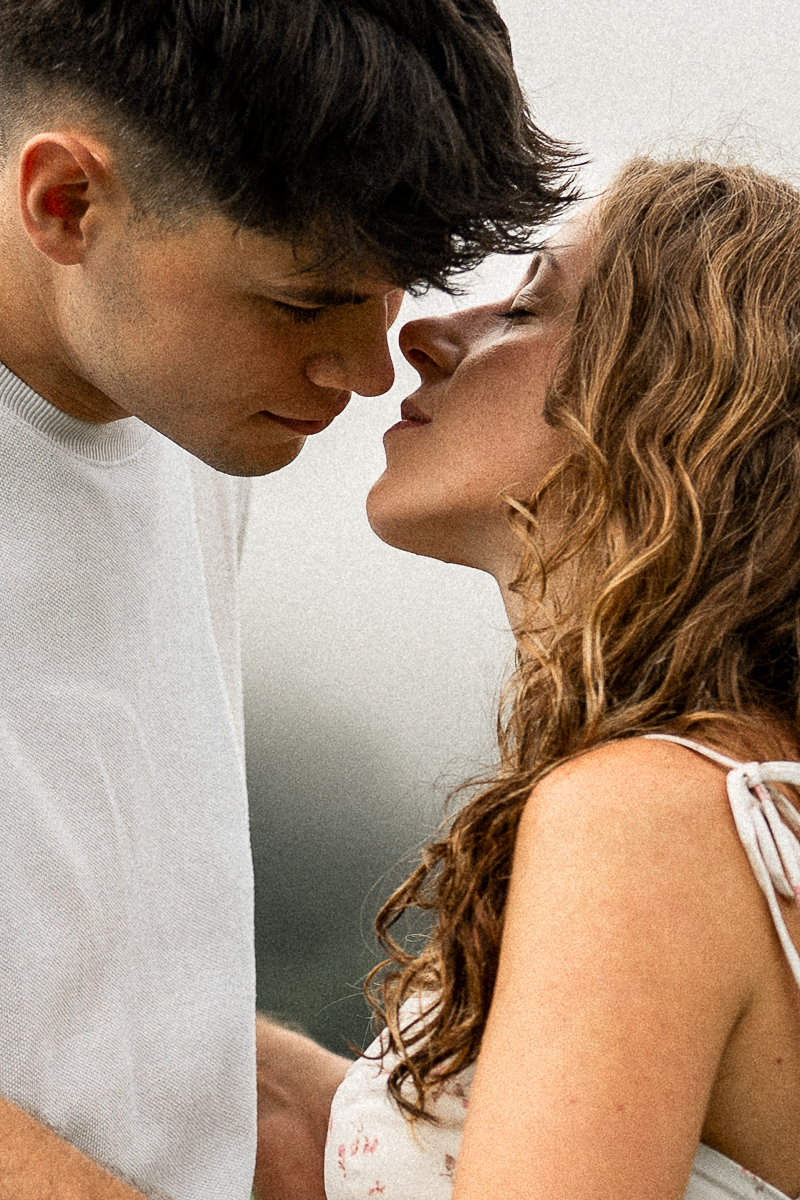 Couple just before a kiss in front of a mystical cloud-filled sky