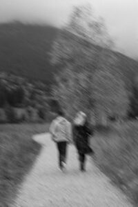 Black-and-white photo with strong motion blur of a couple walking toward the mountains