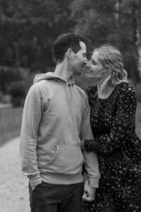 Medium close-up black-and-white photo of a young couple walking just before a kiss