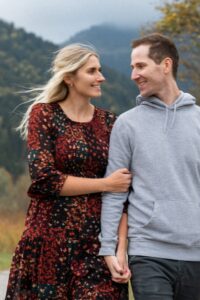 Young couple walking along a path while laughing and holding hands