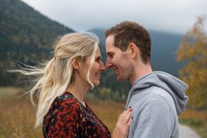 Couple touching noses in the wind while smiling lovingly at each other