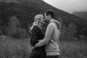 Black-and-white photo of a couple arm in arm just before a kiss