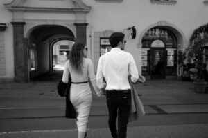 Black-and-white photo of a couple crossing a street