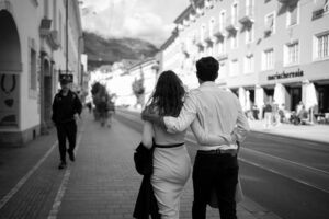 Black-and-white photo from behind of a couple walking through Innsbruck’s Maria-Theresien-Straße
