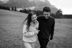Slightly blurred black-and-white photo of a young couple walking through a field